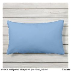 a light blue pillow on a white wooden background with the text medium wedwood is pillow by colored pillows