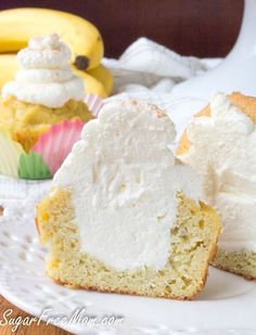 two cupcakes with white frosting sitting on a plate next to some bananas