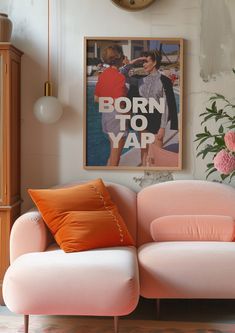 a pink couch sitting in front of a clock on the wall next to a vase with flowers