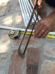 a man measuring the width of a brick wall