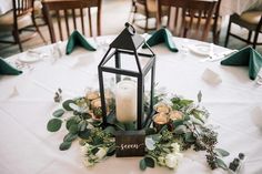 a table topped with a lantern and flowers