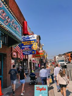 people walking down the sidewalk in front of shops