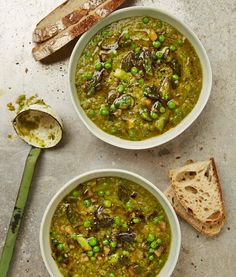 two bowls of soup with bread on the side