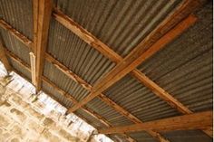 the inside of a building that has metal roofing and wood beams on top of it