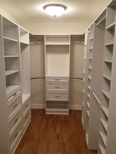 an empty walk in closet with drawers and shelves