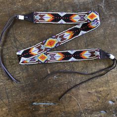 two beaded lanyards sitting on top of a wooden table