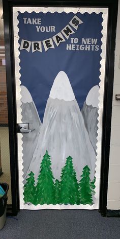 a classroom door decorated with an image of mountains and pine trees that reads take your day dream to new heights