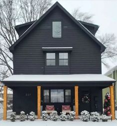 a black house with snow on the ground