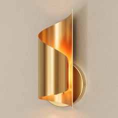 a gold wall light mounted to the side of a white wall