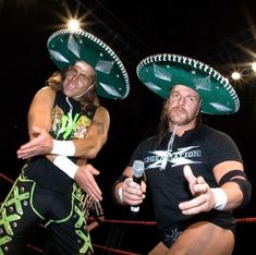 two men wearing sombreros on their heads standing next to each other in a ring