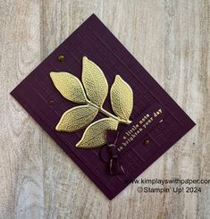 a purple card with gold leaves on it