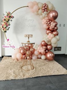 a balloon arch is decorated with pink, white and gold balloons