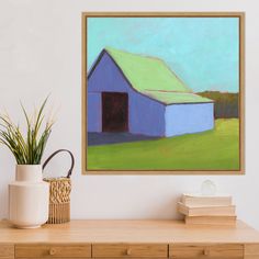 a blue barn with a green roof is on the wall next to a vase and books