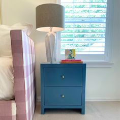 a blue nightstand next to a bed in a bedroom