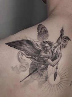 a man with an angel tattoo on his back holding a spear and shield in one hand