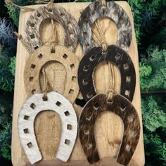 four different types of horseshoes sitting on top of a wooden board