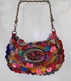 Handmade textured bag with colorful 3D flowers covering the outside. Metal accents around the top handle, shoulder strap, and magnetic buttons to snap purse closed.  Relaxed and adaptable material that's easy to fold and style in a variety of ways. Shoulder strap can be unhooked and removed. Multicolor Shoulder Bag With Detachable Handle As Fashion Accessory, Multicolor Spring Bags, Flower Shaped Multicolor Shoulder Bag, Spring Multicolor Leather Shoulder Bag, Multicolor Leather Shoulder Bag For Spring, Multicolor Crossbody Shoulder Bag With Magnetic Closure, Multicolor Clutch Shoulder Bag With Detachable Strap, Multicolor Shoulder Bag With Magnetic Closure For Everyday Use, Multicolor Leather Bag With Magnetic Closure