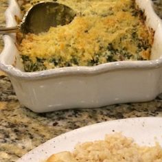 a casserole dish on a plate with a serving spoon next to the casserole