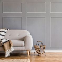 a living room with a couch, chair and rug in front of a gray wall