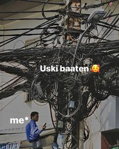 a man standing next to an electric pole with wires all over it and the words uski baten on it