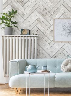 a living room with a blue couch and coffee table in front of a white radiator