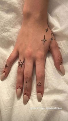 a woman's hand with three stars on it and two hearts in the middle