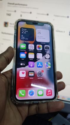 someone holding an iphone in their hand with various icons on the screen and back side