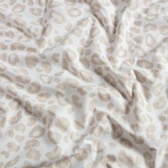 an animal print fabric is shown in beige and white colors, as well as brown spots