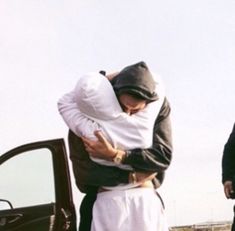 two men standing next to each other in front of a truck