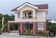 a pink and white two story house with red tiled roof