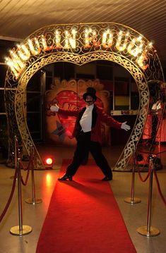 a man walking down a red carpeted floor next to a sign that says museum