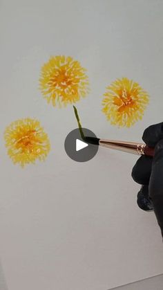 someone is painting yellow flowers on the wall