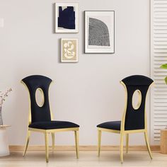 two black chairs sitting next to each other in front of a wall with pictures on it