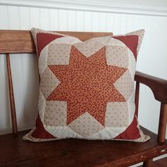 a red and white pillow sitting on top of a wooden chair