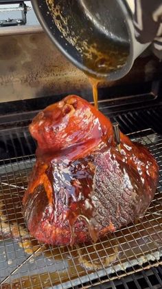 someone is pouring sauce on a piece of meat that has been cooked in the oven