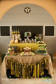 a table topped with lots of cakes and desserts next to a star decoration on the wall