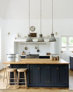 a kitchen with blue cabinets and wooden counter tops