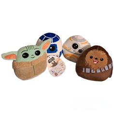 three star wars plush toys are lined up on a white background, one has an egg and the other has a baby yoda