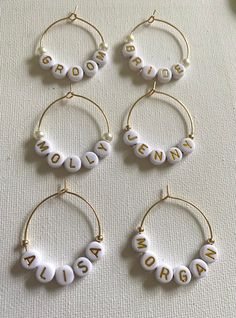 four pairs of personalized hoop earrings in white and gold, with the word mom written on them