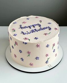 a white cake with purple and blue flowers on it