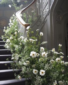 some white flowers are growing on the stairs