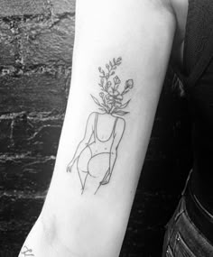 a black and white photo of a woman's arm with a flower tattoo on it