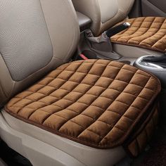 two seats in the back of a car, one with a seat cover on it