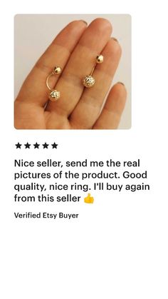 a hand holding an open ring with two balls on it and the text nice seller, send me the real pictures of the product good quality