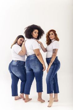 three women in white shirts and jeans posing for the camera