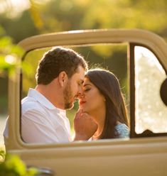 a man and woman sitting in the back of an old pickup truck looking into each other's eyes