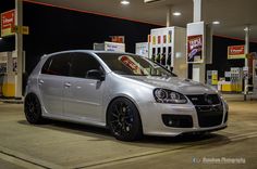 a white car parked in front of a gas station