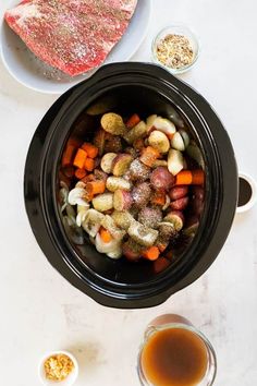 an overhead view of some meat and vegetables in a crock pot on a table