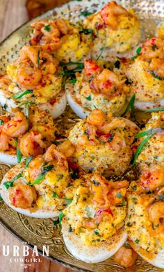 an image of deviled eggs with shrimp and herbs on them in a platter