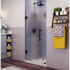 a bathroom with a glass shower door and towel racks on the wall next to it